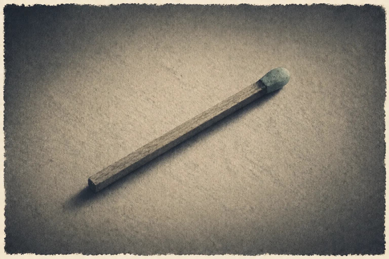 A single unlit match lying on cream paper.